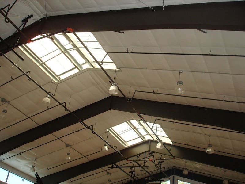 Insulation and reflective roof coating installed to improve energy efficiency in a prefab building