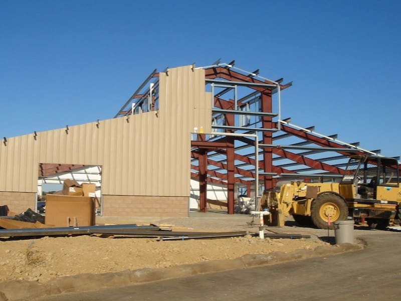 Steel frame of a steel building under construction at a job site.